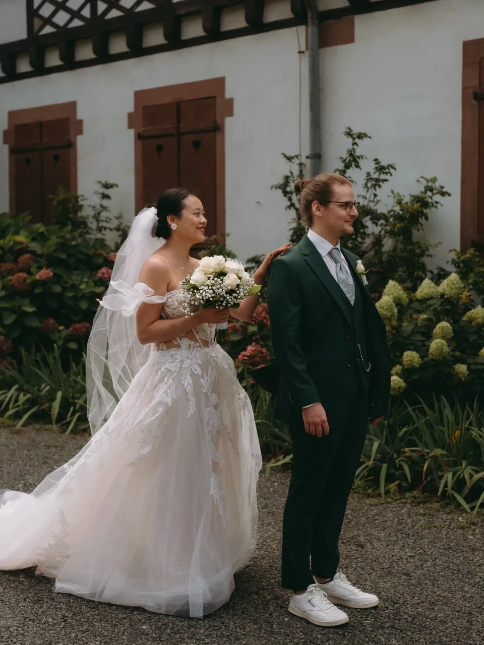 Braut tippt dem Bräutigam beim First Look auf die Schulter