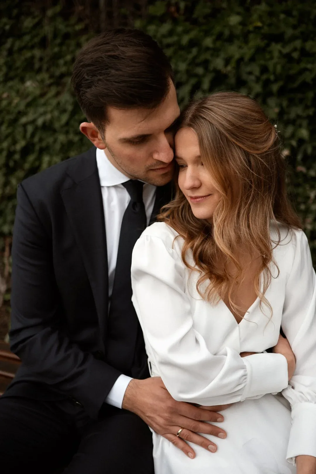 Brautpaar innige Umarmung auf der Bank