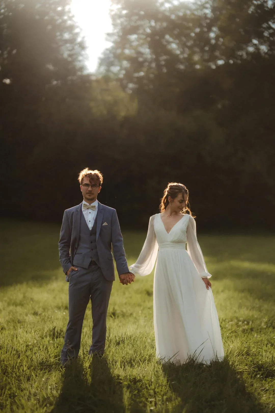 Brautpaar Hand in Hand in Sonnenstrahlen